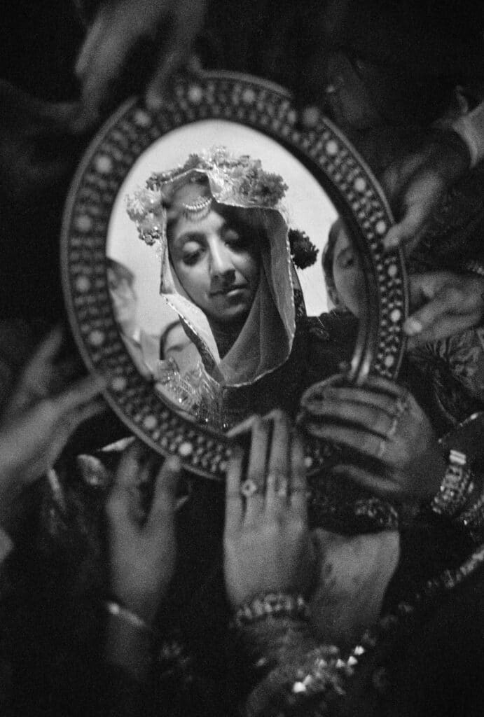 Young groom discovering his wife's face in a mirror, Lahore, Pakistan, 1952