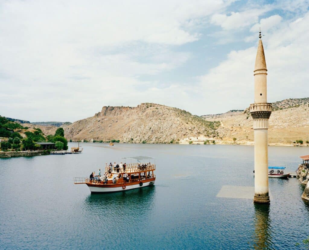 A tourist boat tour is visiting the former village of Savacan flooded by the reservoir lake of the Birecik Dam in 1999 located on the Euphrates river. Turkey. © Mathias Depardon
