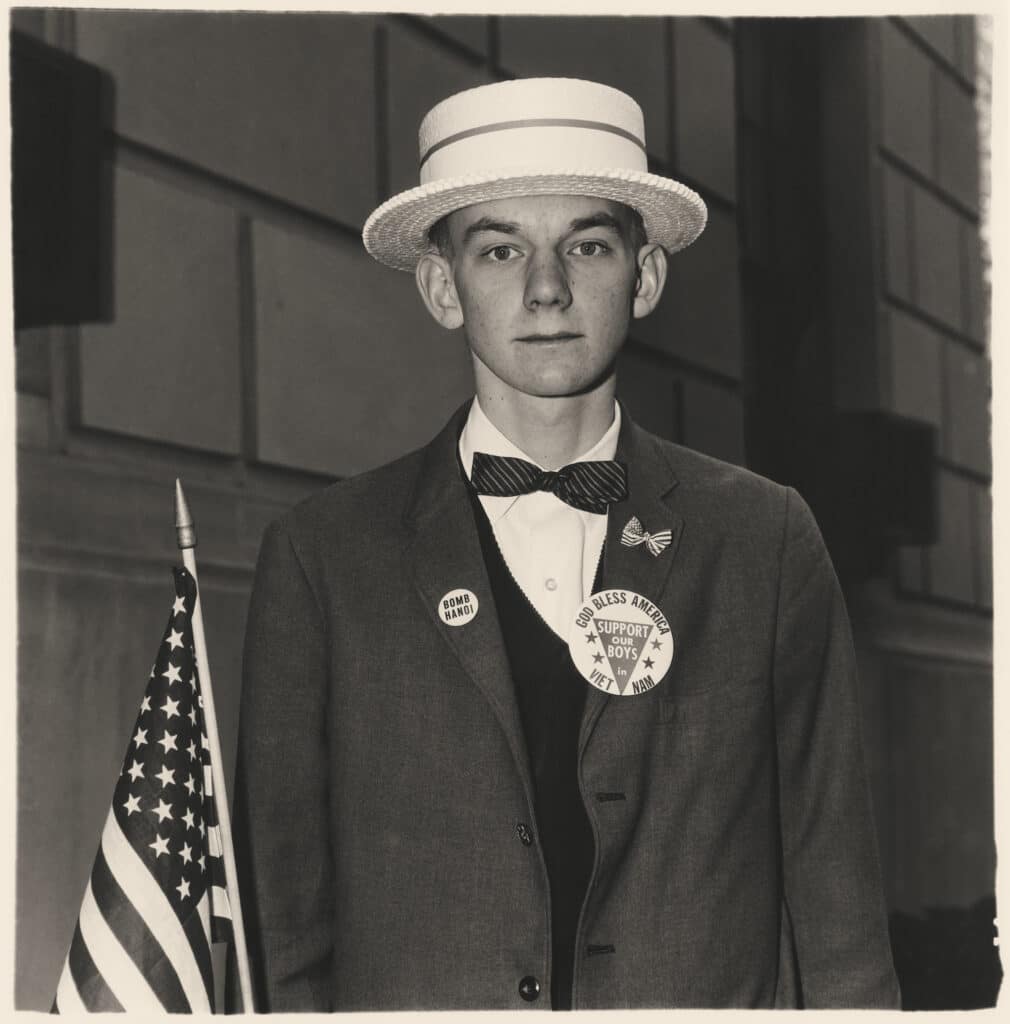 Boy with a straw hat waiting to march in a pro-war parade, NYC, 1970 © Diane Arbus