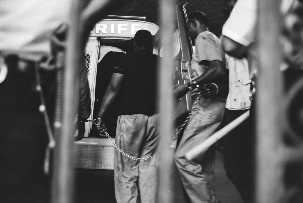 Des personnes arrêtées enchaînées sont embarquées dans une camionnette du shérif, Newark, juillet 1967 © Bud Lee, Estate of Bud Lee