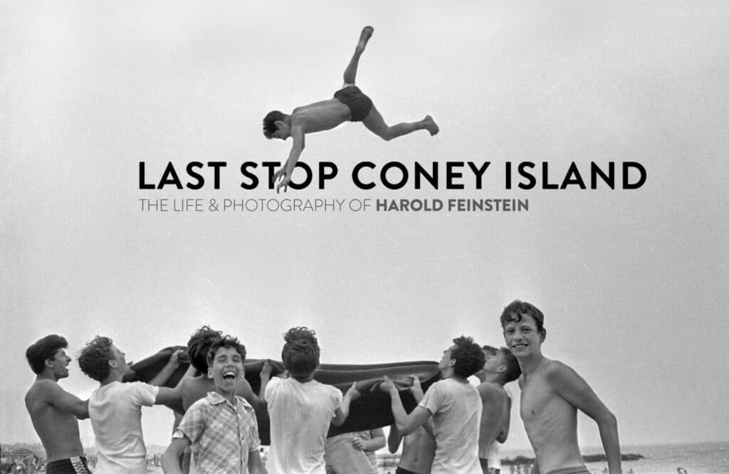 A group of boys flings another boy high in the air as part of a blanket toss game at a Coney Island beach, New York, 1955.