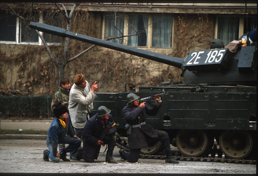 Du 22 au 23 décembre 1989 la Roumanie vit une révolution étrange. Dans les rues la population assiste la police et l'armée dans la bataille contre les"contre- révolutionnaires" de la Sécutitat"restés fidele au dictateur en fuite. En fait c'est l'Armée qui a renversé le régime et laisse croire à une résistance de la Sécutitat avec ces incendies, ces combats de rue, ces cadavres recousus sortis des morgues. Comédie ? Tragédie ? Série Chroniques visuelles d'une fin de siècle © Marc SIMON