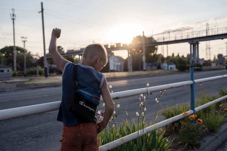 Timor, 9 ans, lève le poing pour saluer des militaires qui passent, criant : "Gloir à l'Ukraine" ou "Les Russes sont des porcs" à Droujkivka, Donbass, Ukraine, le 4 juin 2022.