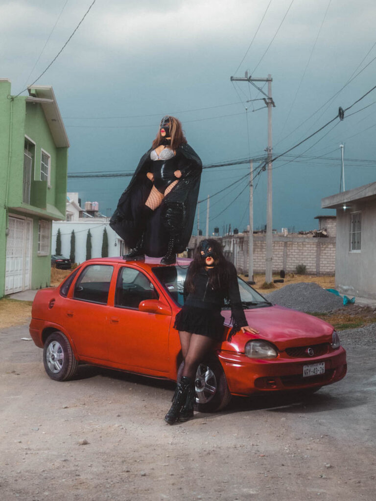 Mexico, Mexico City, 2023/03/12. Sexy Angelical and her daughter Dama Divina pose on a car in the suburbs of Cholula, in front of the gymnasium they built. Photography by Theo Saffroy