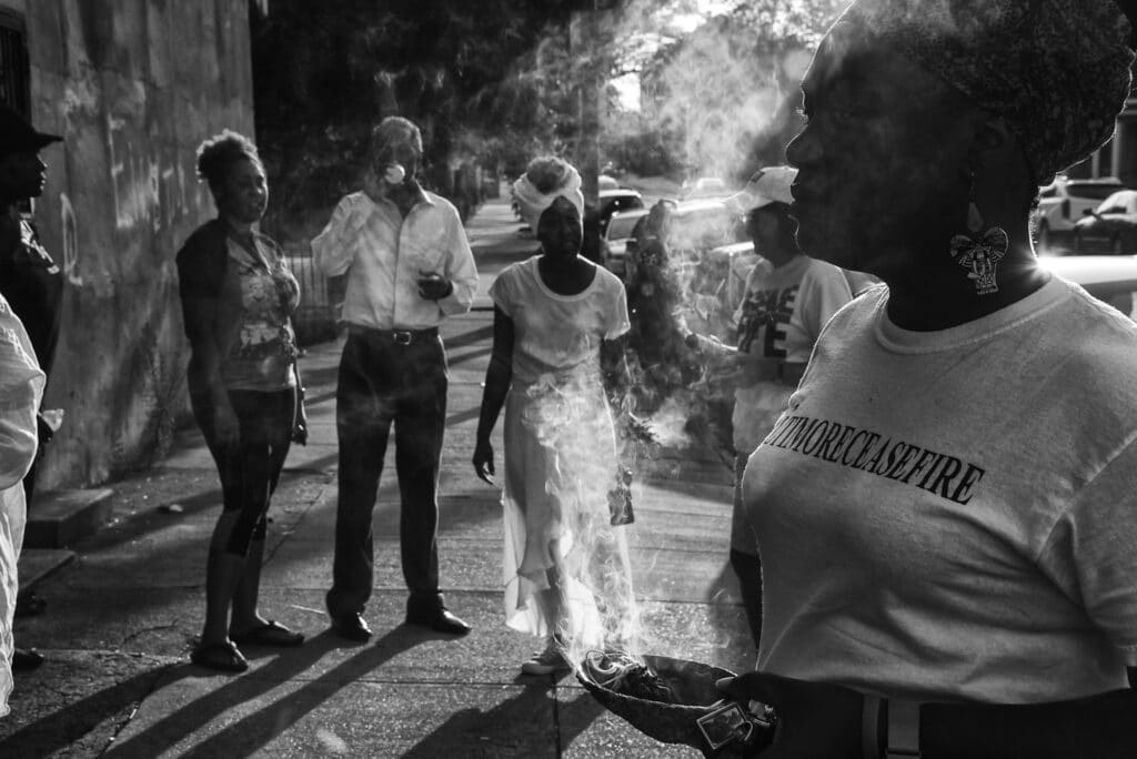 Des volontaires de Baltimore Ceasefire brûlent de la sauge à l'angle de Broadway et d'Eager Street, lundi soir, à la suite d'une fusillade survenue la nuit précédente pendant le week-end de Ceasefire.