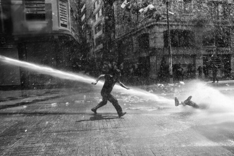 During Gezi protests, police use water canon to disperse the crowd on Istiklal street, near Taksim Square. The civil unrest began in May 2013 after the violent eviction of a sit-in at the park protesting an urban development plan. Turkey, Istanbul, May 2013 © Emin Özmen