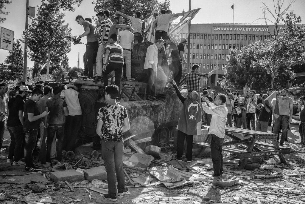 People stand on a damaged military tank in Ankara, near the Palace of Justice, a day after a failed coup attempt by the Turkish military in which at least 265 people died, including soldiers, police and civilians. Turkey, Ankara, July 2016 © Emin Özmen